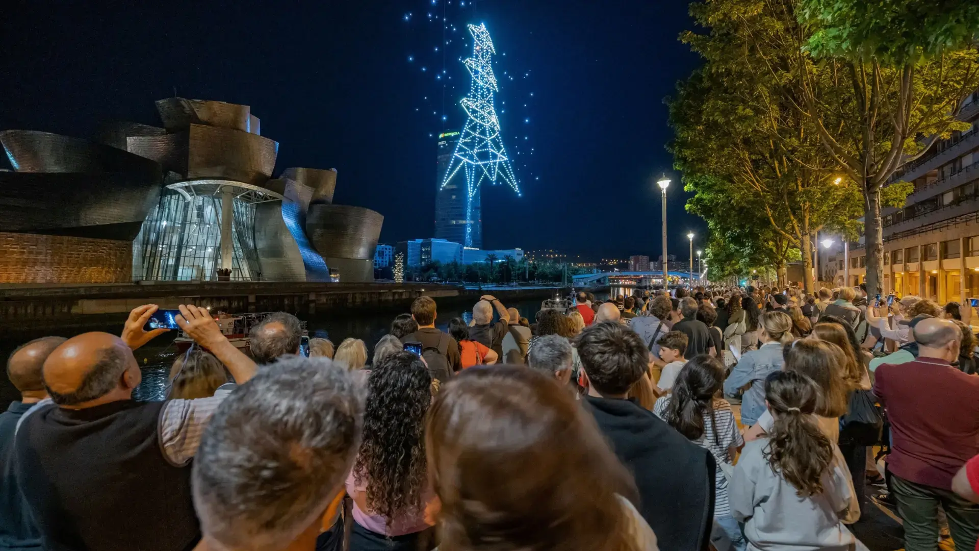 Público en Bilbao viendo drones Gente disfrutando del espectáculo nocturno