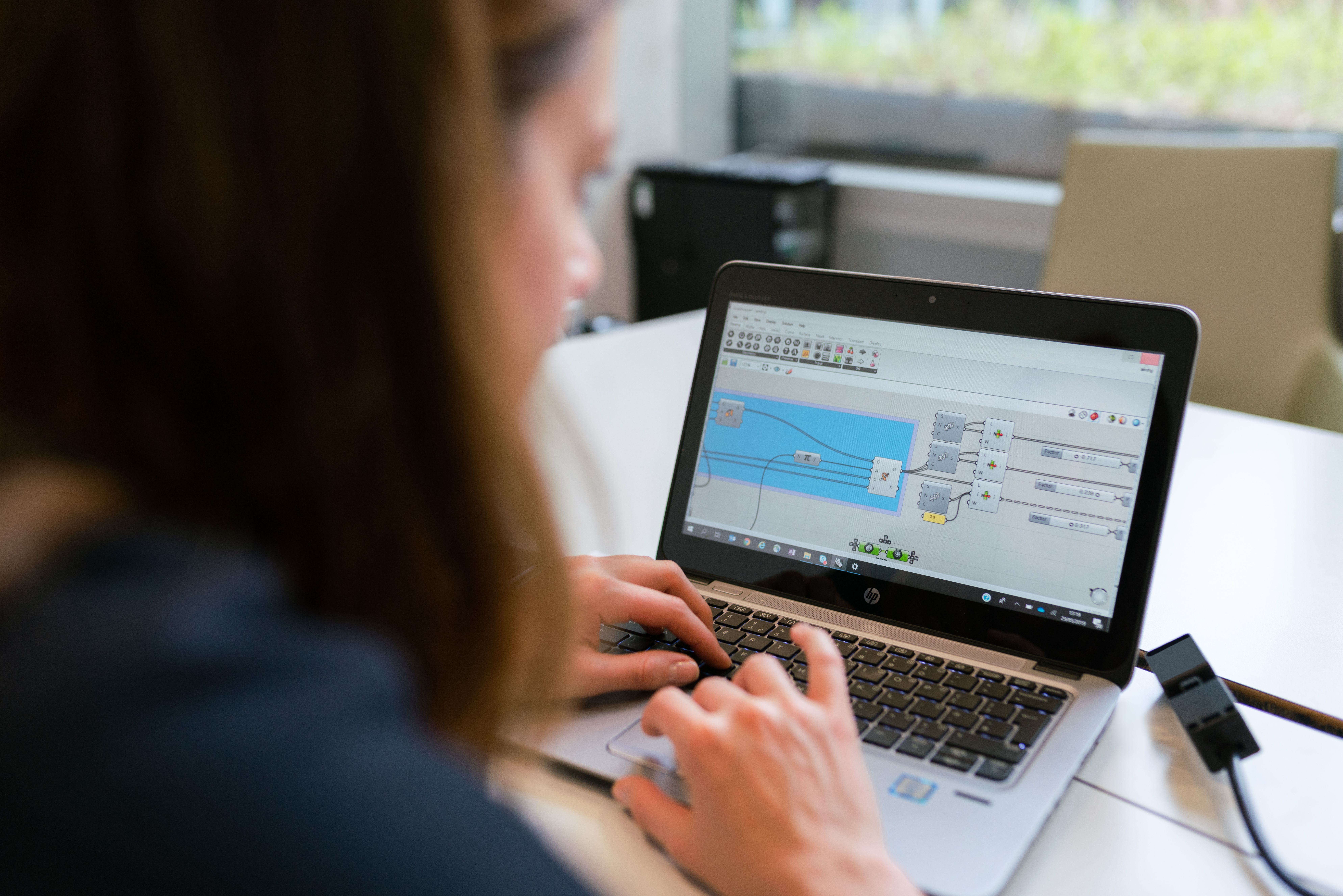 Ingeniera de software trabajando en el diseño lógico de un sistema mediante una interfaz de programación visual basada en nodos. Ingeniera de software trabajando en el diseño lógico de un sistema mediante una interfaz de programación visual basada en nodos.