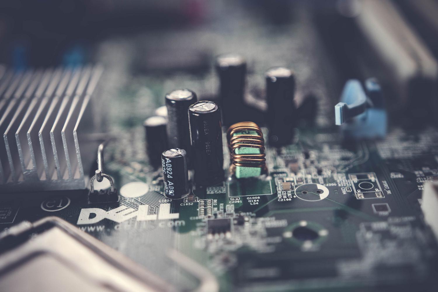Detalle técnico de una placa base con condensadores y circuitos electrónicos, ilustrando los procesos de reset a nivel de hardware. Detalle técnico de una placa base con condensadores y circuitos electrónicos, ilustrando los procesos de reset a nivel de hardware.