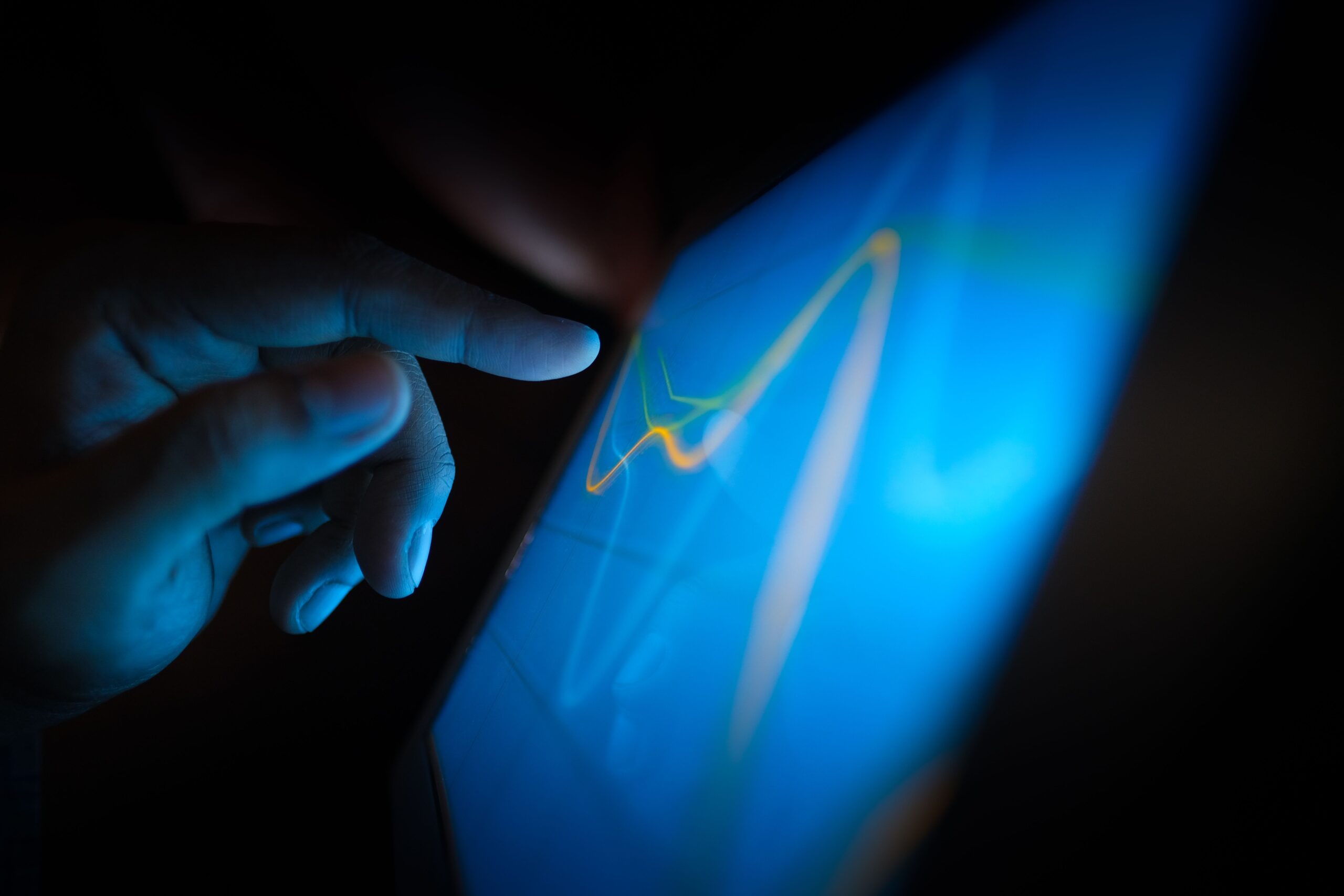Primer plano de una mano interactuando con un monitor táctil que muestra gráficos de datos Primer plano de una mano interactuando con un monitor táctil que muestra gráficos de datos