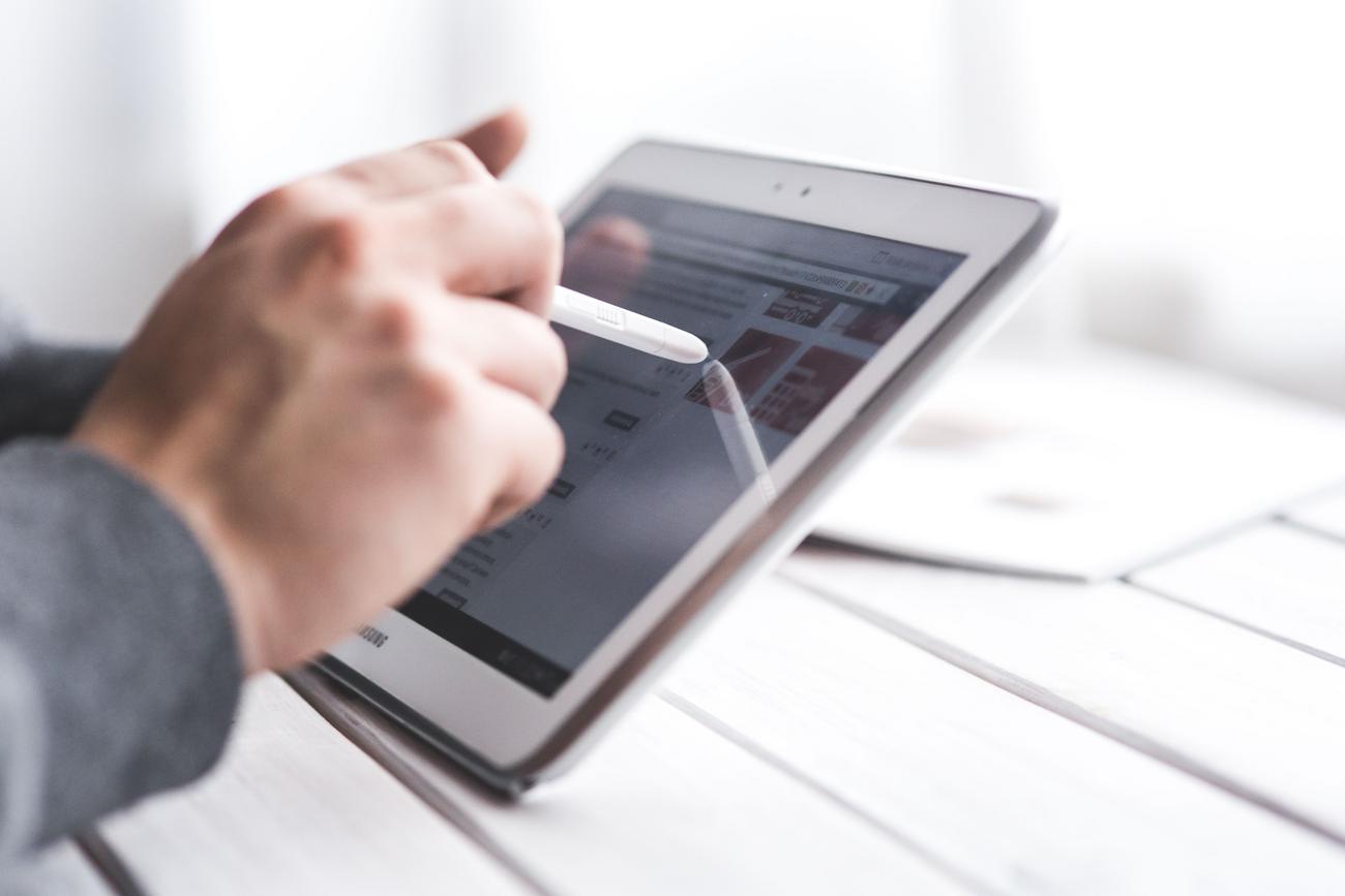 Primer plano de una mano utilizando un lápiz óptico sobre la pantalla de una tablet Primer plano de una mano utilizando un lápiz óptico sobre la pantalla de una tablet