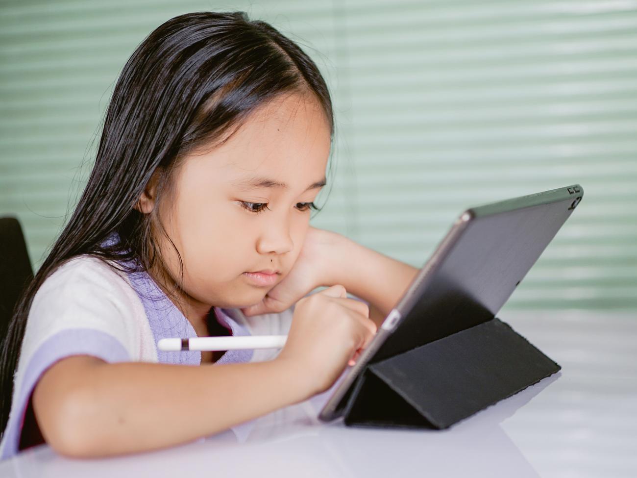 Niña utilizando una tablet y un lápiz digital para el aprendizaje online Niña utilizando una tablet y un lápiz digital para el aprendizaje online