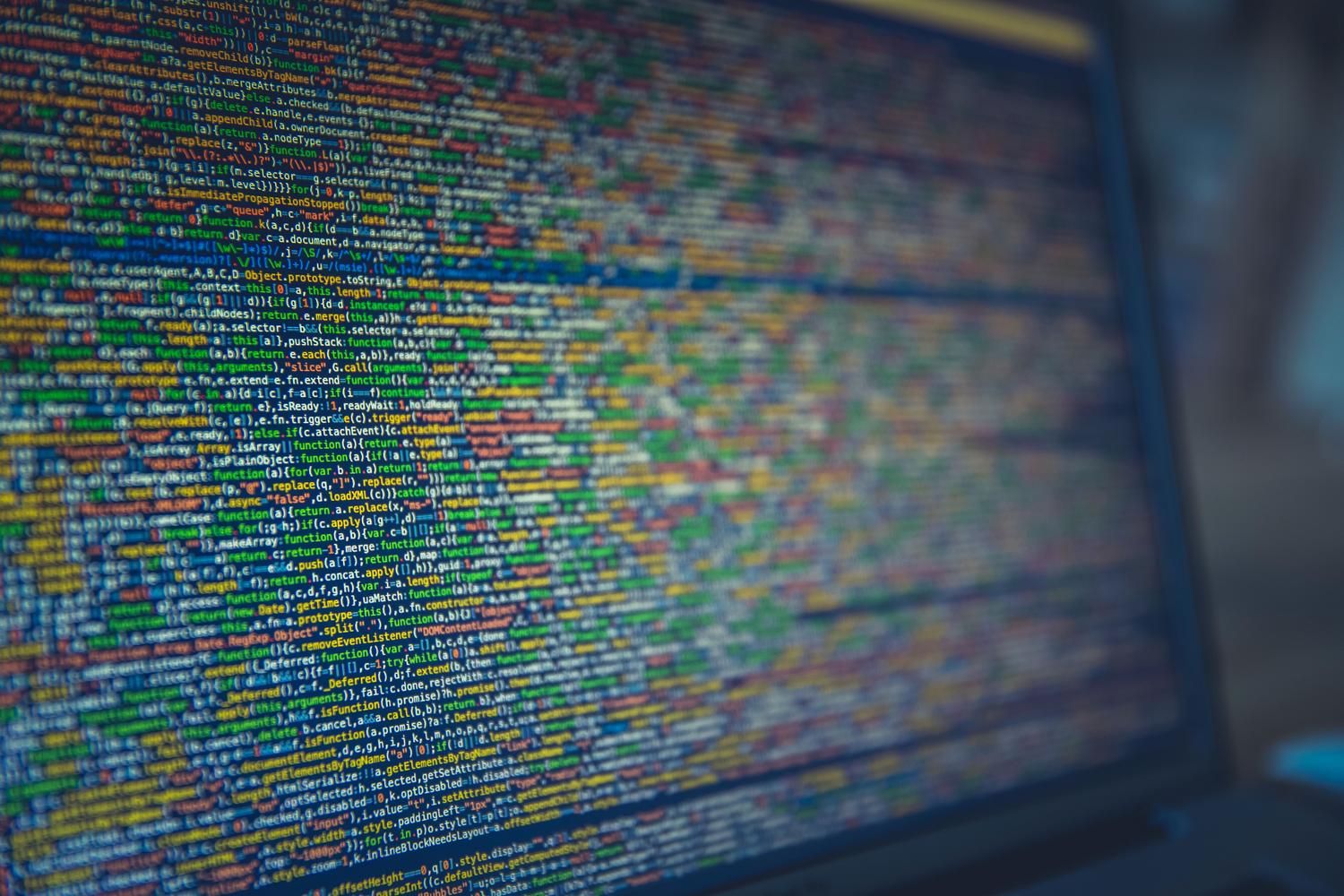 Código fuente en pantalla que ilustra software abierto y cerrado Primer plano de código fuente colorido en una pantalla, útil para explicar la diferencia entre código abierto y cerrado.