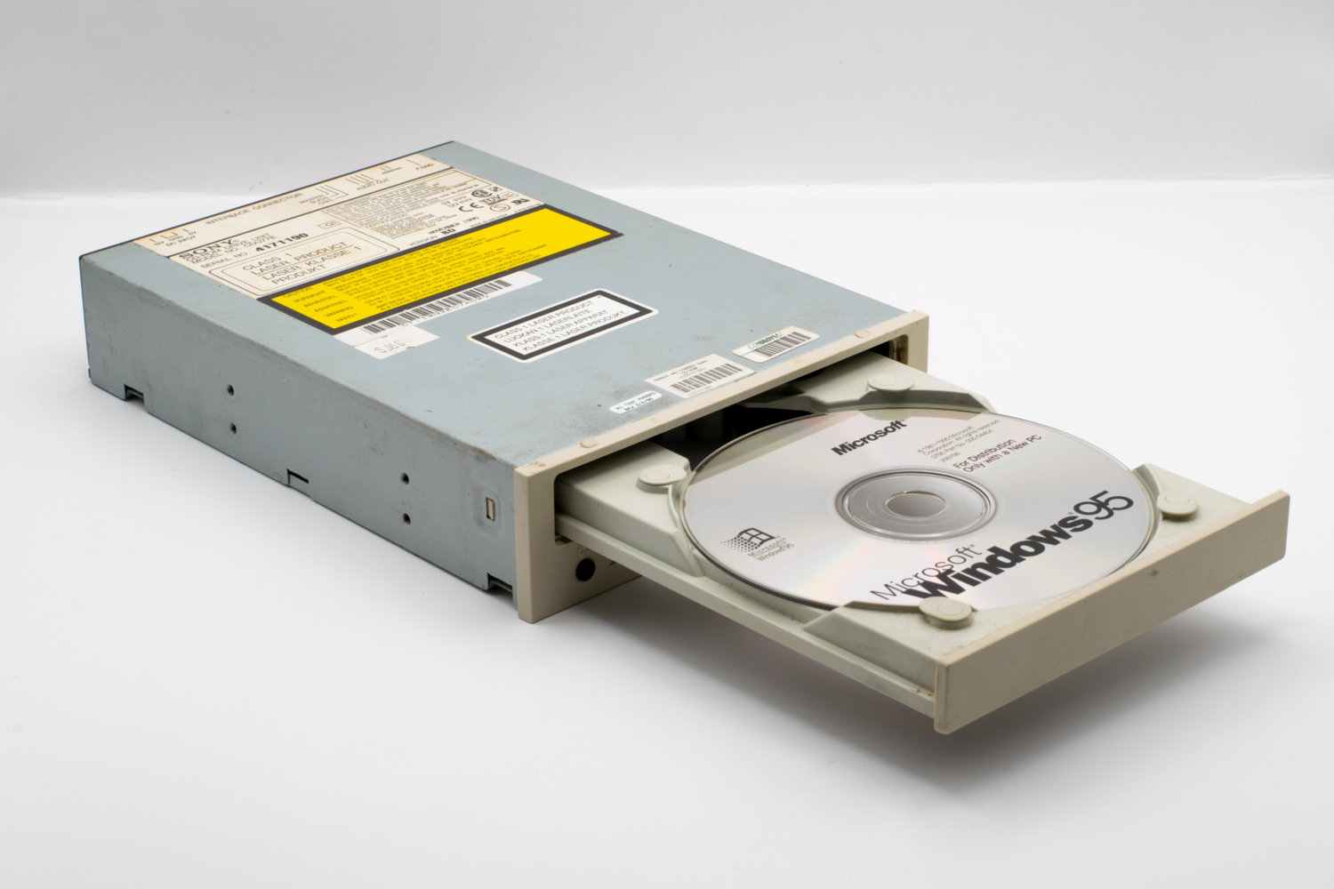 Disco de Windows antiguo que ilustra el origen del shareware Un disco de Windows 95 en una unidad de CD-ROM antigua, ilustrando los orígenes históricos del software shareware.