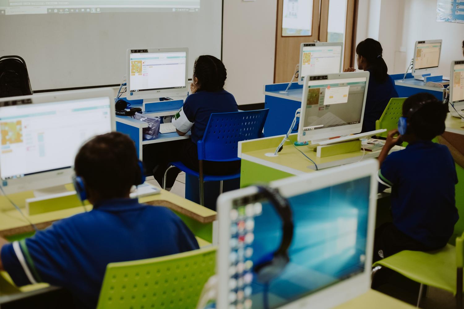 Niños aprendiendo informática en una aula moderna, representando la necesidad de fomentar las disciplinas STEM desde edades tempranas. Niños aprendiendo informática en una aula moderna, representando la necesidad de fomentar las disciplinas STEM desde edades tempranas.