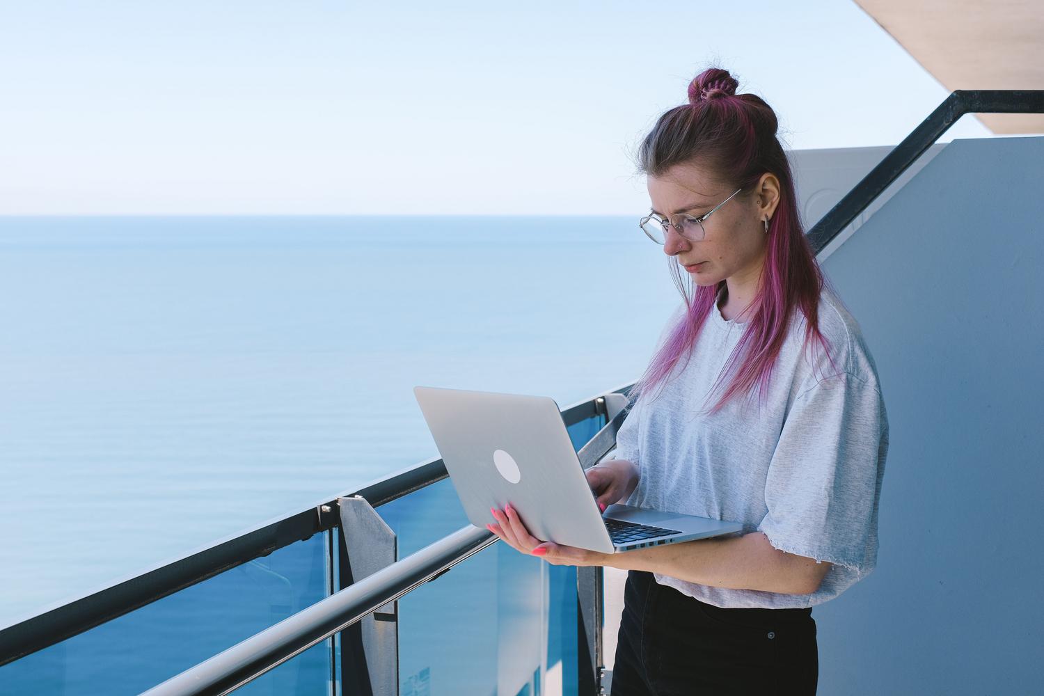 Mujer trabajando remotamente en un entorno relajado, ilustrando la flexibilidad laboral y la competencia global por el talento tecnológico. Mujer trabajando remotamente en un entorno relajado, ilustrando la flexibilidad laboral y la competencia global por el talento tecnológico.