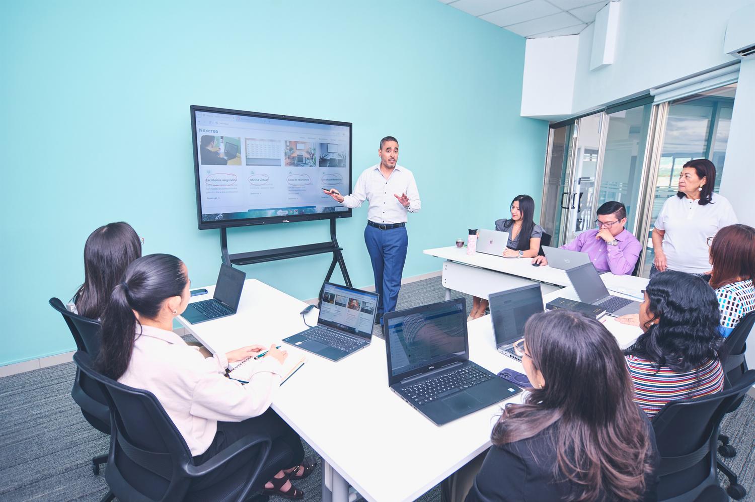 Equipo de profesionales en una presentación digital en la oficina, representando el reskilling y la formación interna de los empleados. Equipo de profesionales en una presentación digital en la oficina, representando el reskilling y la formación interna de los empleados.
