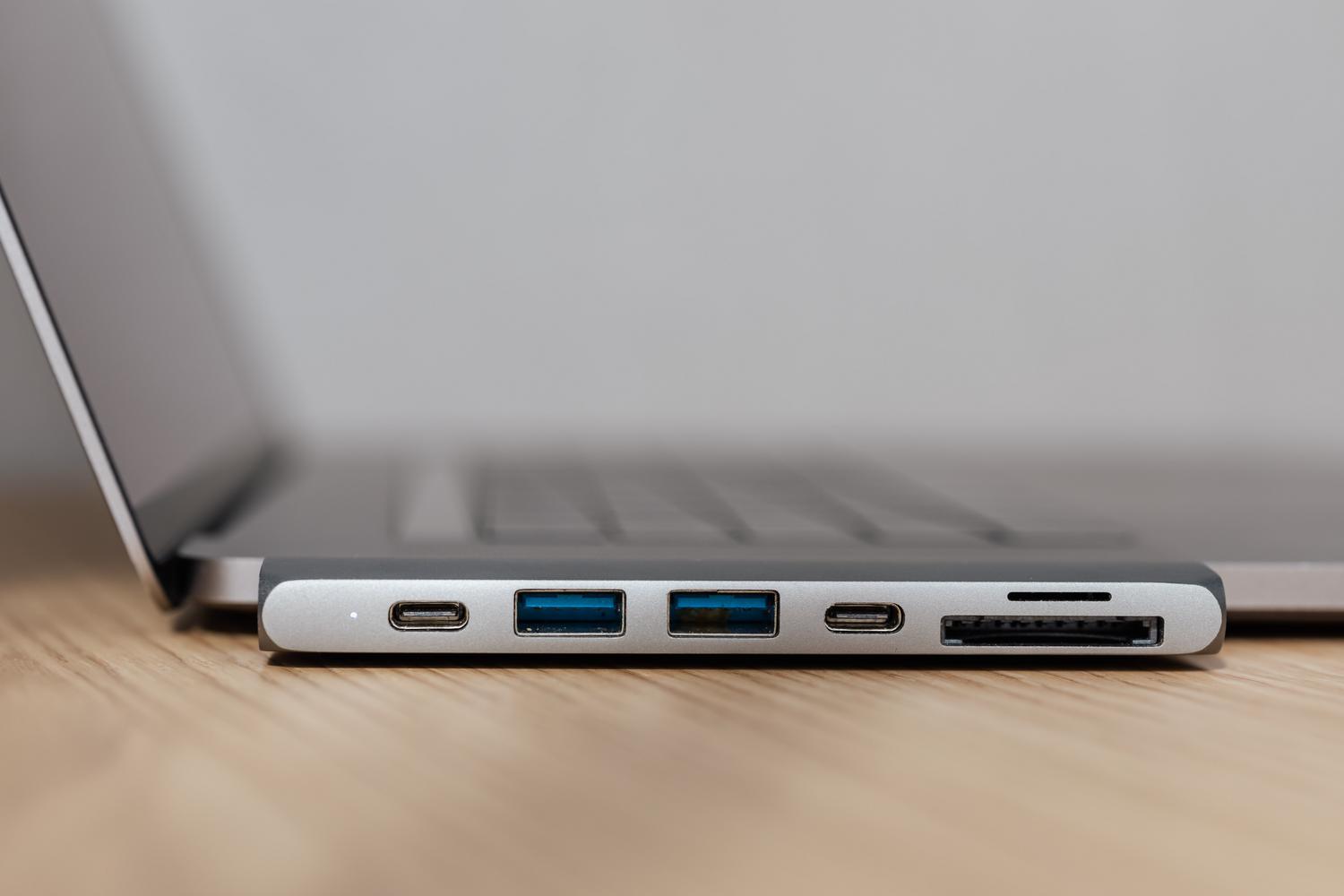 Hub USB-C multiport conectado a un portátil, ilustrando las opciones de conectividad Thunderbolt y USB-C. Hub USB-C multiport conectado a un portátil, ilustrando las opciones de conectividad Thunderbolt y USB-C.