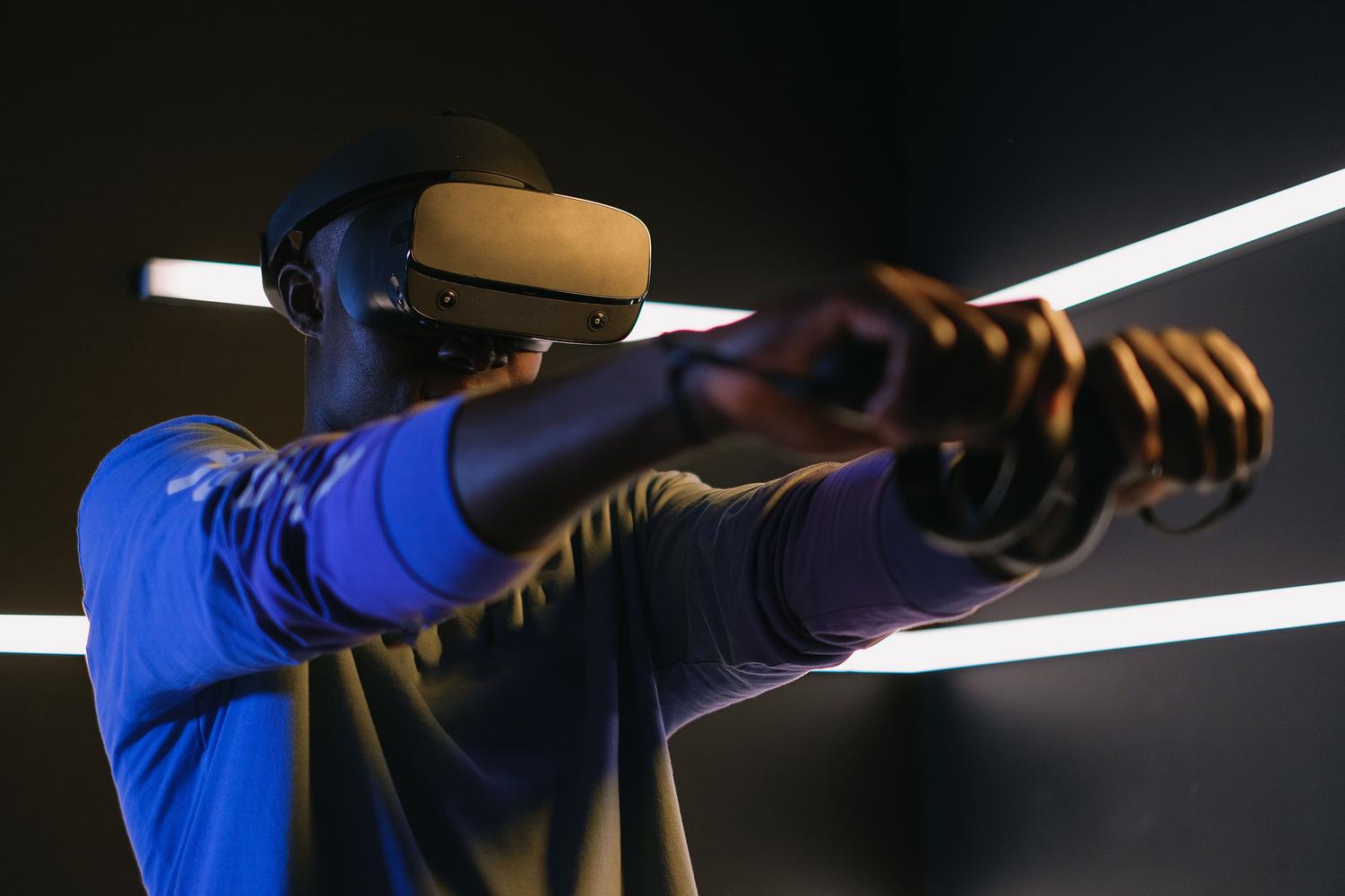 Hombre utilizando gafas de realidad virtual en un entorno moderno, destacando la baja latencia necesaria para la Realidad Extendida (XR). Hombre utilizando gafas de realidad virtual en un entorno moderno, destacando la baja latencia necesaria para la Realidad Extendida (XR).