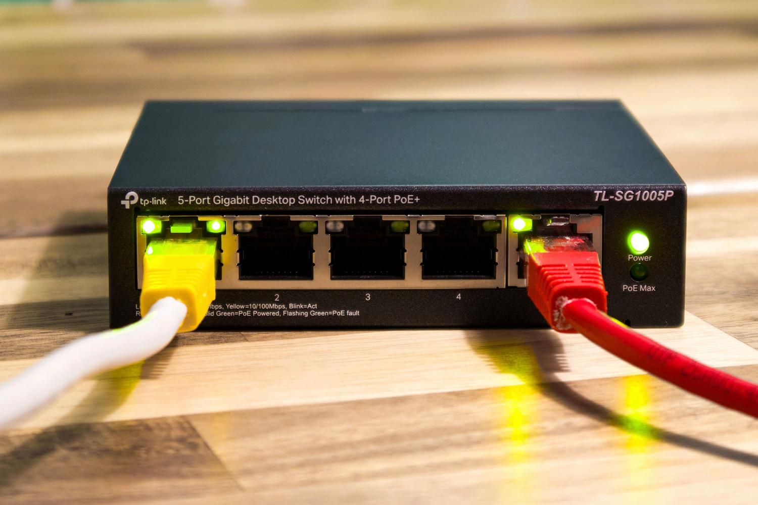 Detalle de cables Ethernet conectados a un switch de red, sirviendo como contraste entre la conexión cableada tradicional y la movilidad del WiFi 7. Detalle de cables Ethernet conectados a un switch de red, sirviendo como contraste entre la conexión cableada tradicional y la movilidad del WiFi 7.