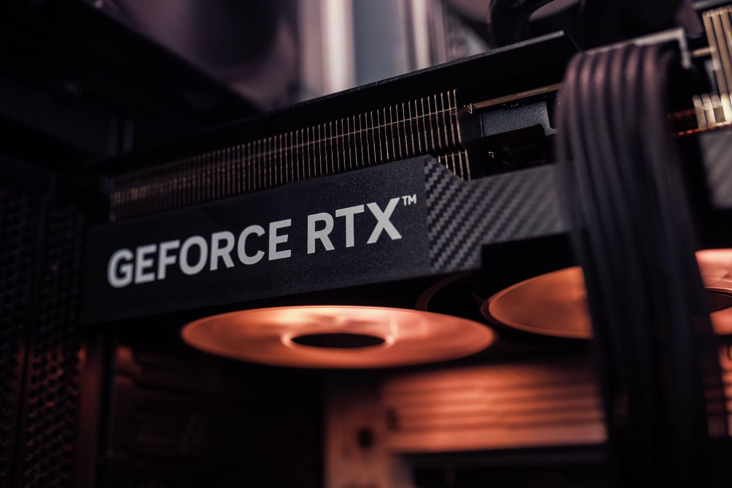 An NVIDIA GeForce RTX graphics card installed inside a PC case with visible power cables and cooling fans. An NVIDIA GeForce RTX graphics card installed inside a PC case with visible power cables and cooling fans.