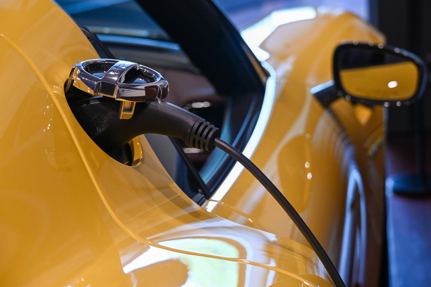 Coche eléctrico amarillo cargándose en una estación, representando la autonomía y eficiencia energética. Coche eléctrico amarillo cargándose en una estación, representando la autonomía y eficiencia energética.