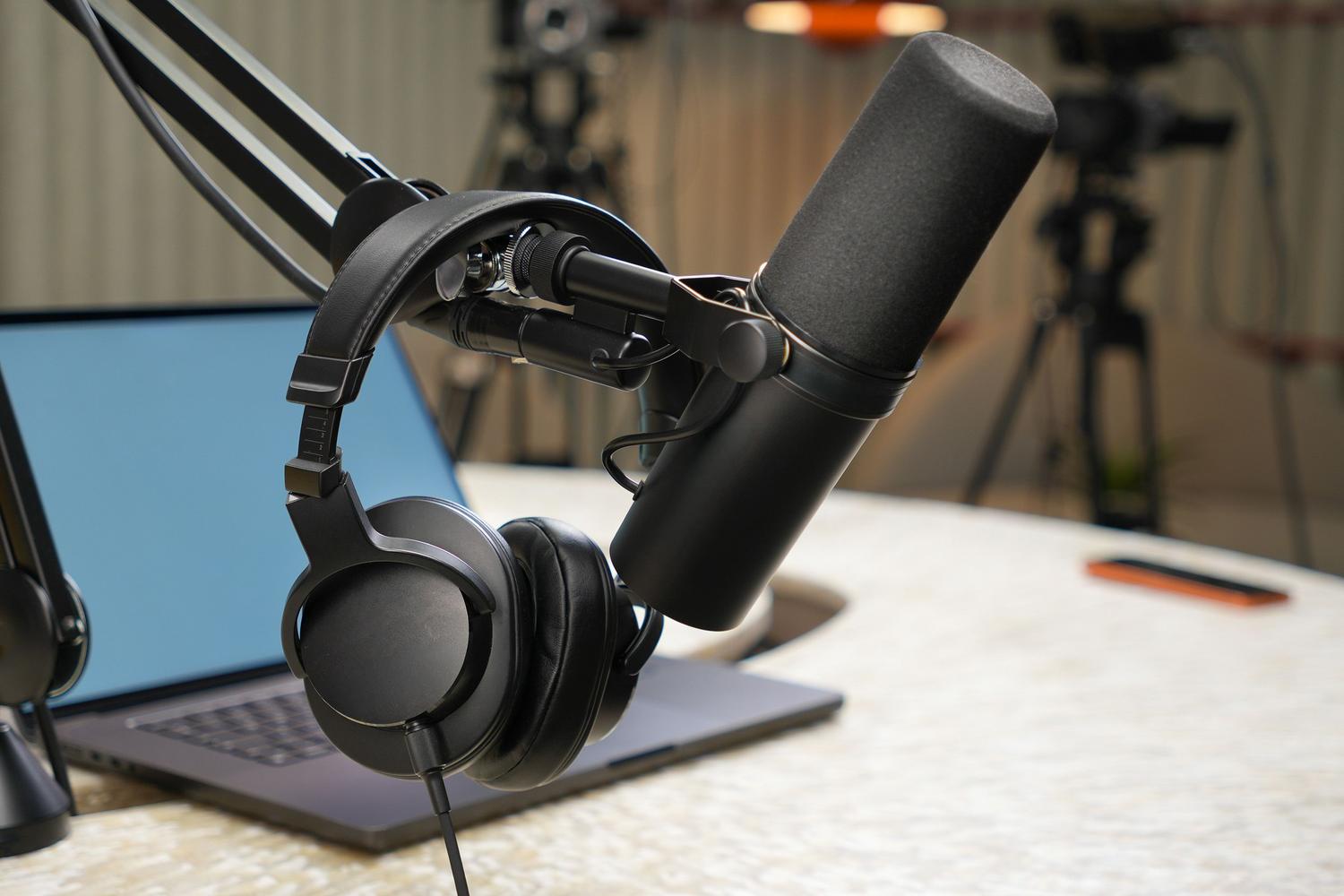 Primer plano de un micrófono de estudio profesional y auriculares para podcasting y radio online Primer plano de un micrófono de estudio profesional y auriculares para podcasting y radio online