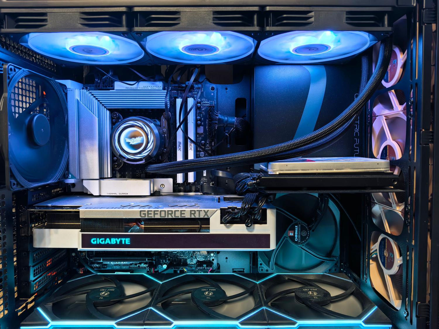 Montaje completo de PC gaming con iluminación RGB coordinada en tonos azules y cian Montaje completo de PC gaming con iluminación RGB coordinada en tonos azules y cian