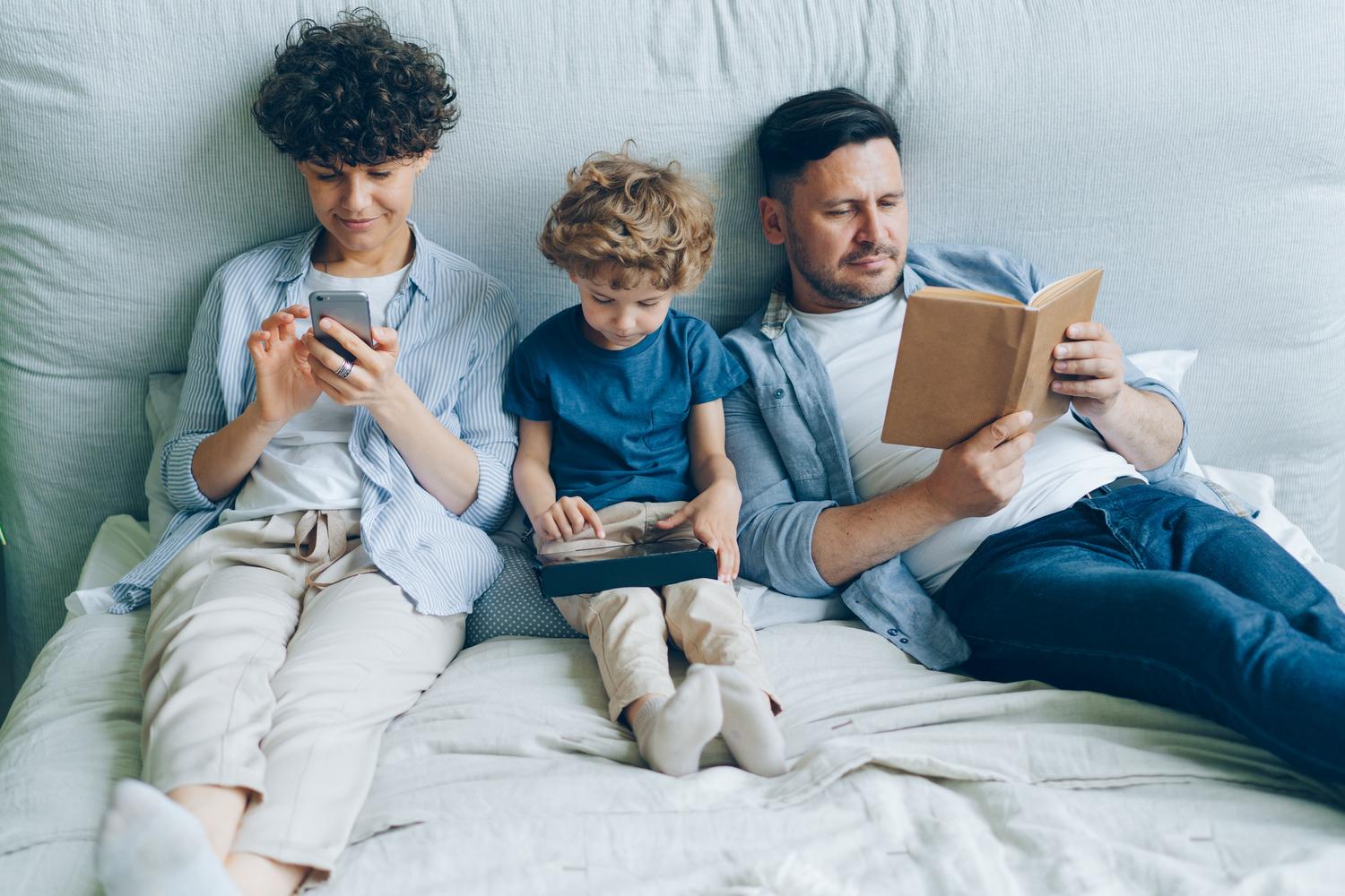 Familia en el hogar con diversos dispositivos electrónicos y un libro, ilustrando el ecosistema digital y el equilibrio con actividades analógicas. Familia en el hogar con diversos dispositivos electrónicos y un libro, ilustrando el ecosistema digital y el equilibrio con actividades analógicas.