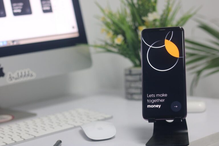 Espacio de trabajo moderno con un smartphone y un ordenador, ideal para ilustrar la reutilización de dispositivos tecnológicos.