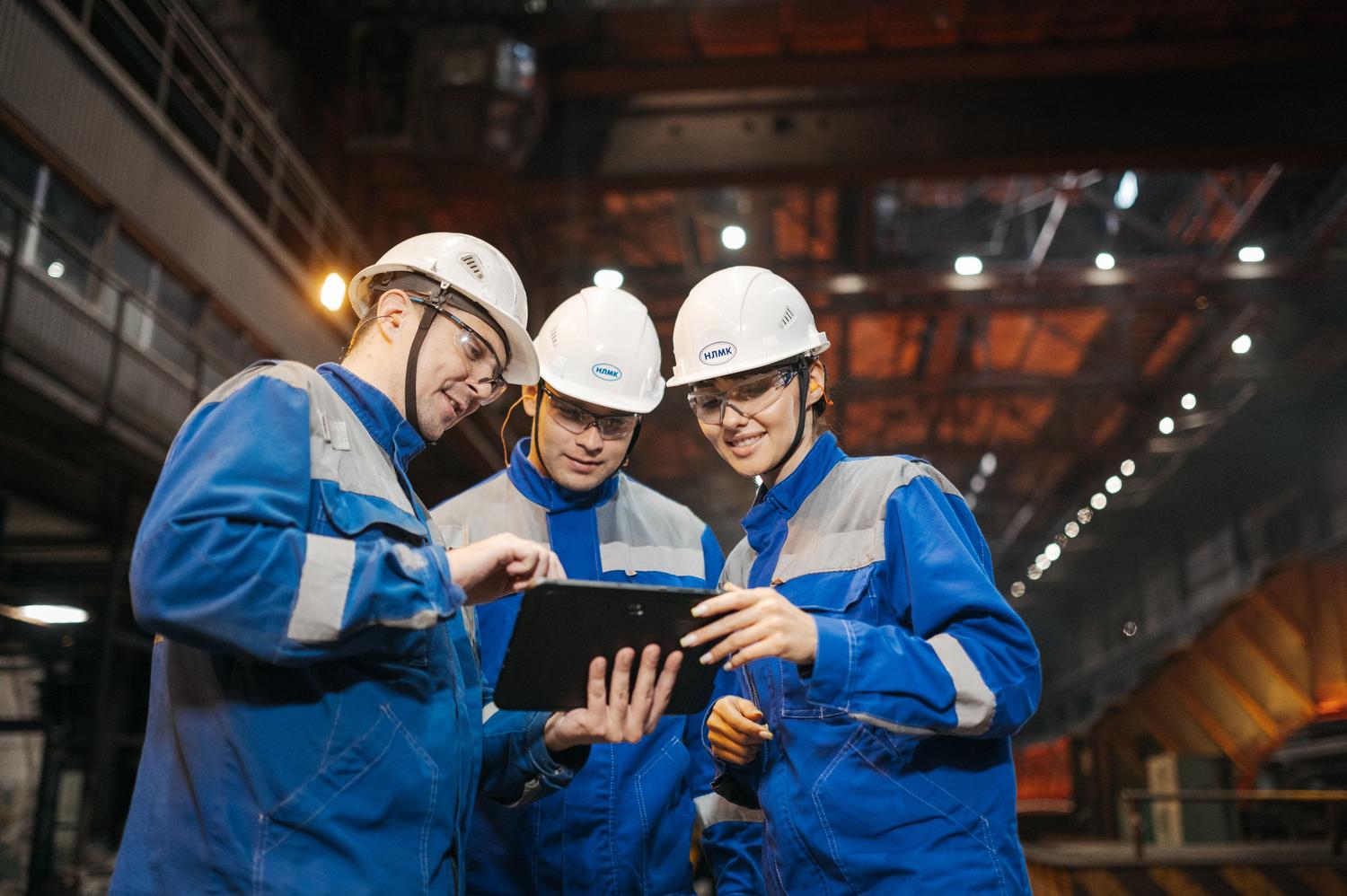 Grupo de ingenieros industriales colaborando y compartiendo conocimientos a través de una tablet en la planta de producción Grupo de ingenieros industriales colaborando y compartiendo conocimientos a través de una tablet en la planta de producción
