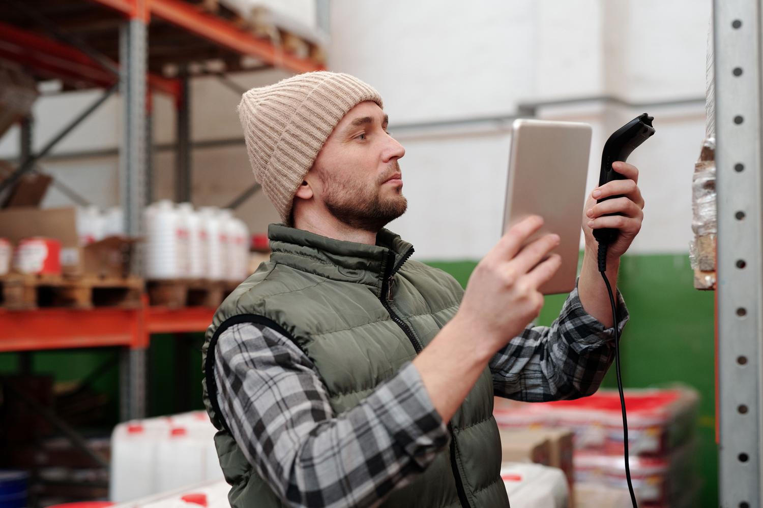 Técnico utilizando un escáner portátil en un almacén industrial para el registro y control de activos Técnico utilizando un escáner portátil en un almacén industrial para el registro y control de activos