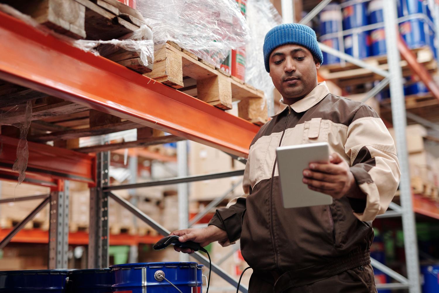 Operario de almacén utilizando una tablet digital para la gestión y trazabilidad del inventario de herramientas Operario de almacén utilizando una tablet digital para la gestión y trazabilidad del inventario de herramientas