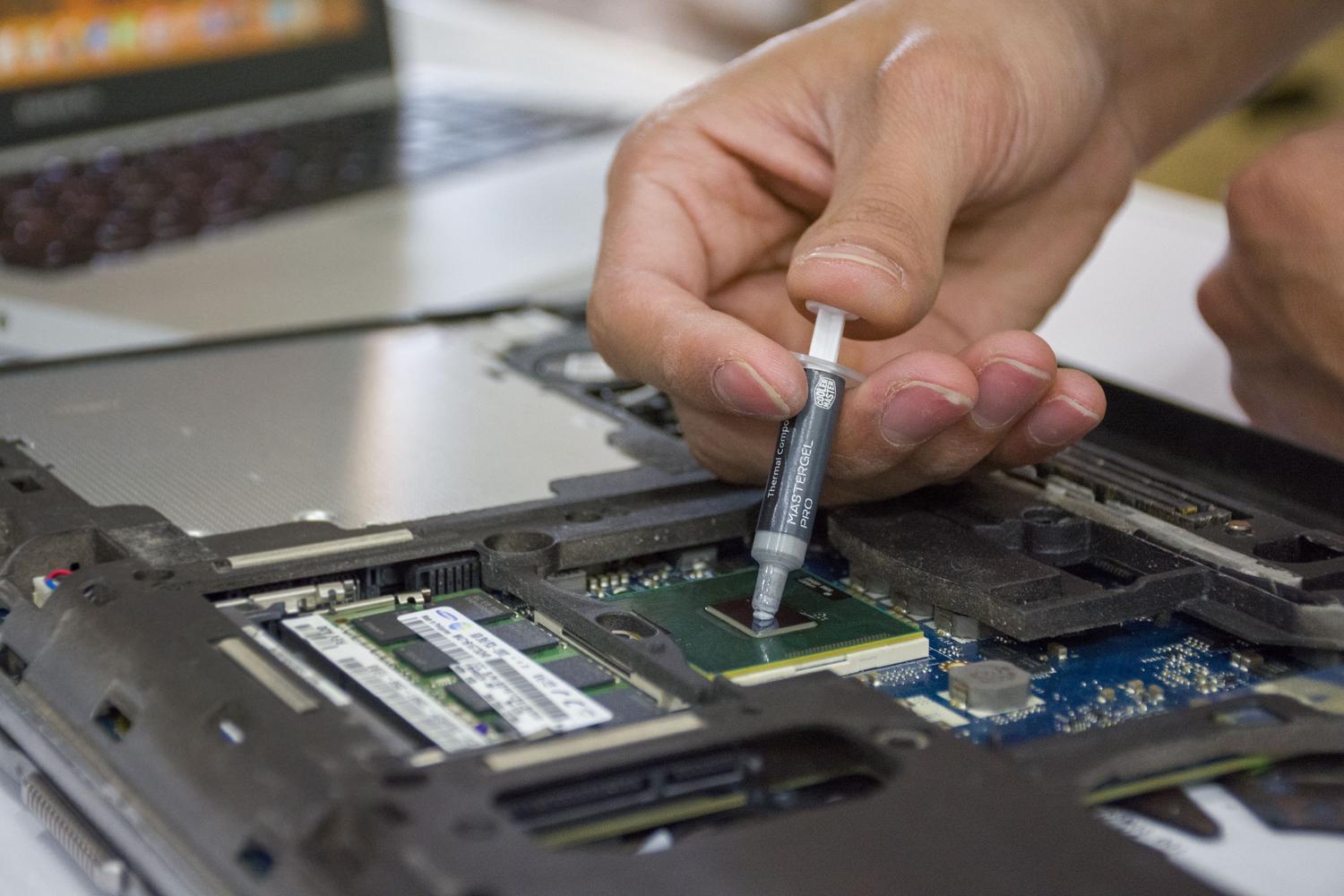 Aplicación de pasta térmica en un microchip, simbolizando la gestión avanzada del estrés térmico en componentes electrónicos. Aplicación de pasta térmica en un microchip, simbolizando la gestión avanzada del estrés térmico en componentes electrónicos.