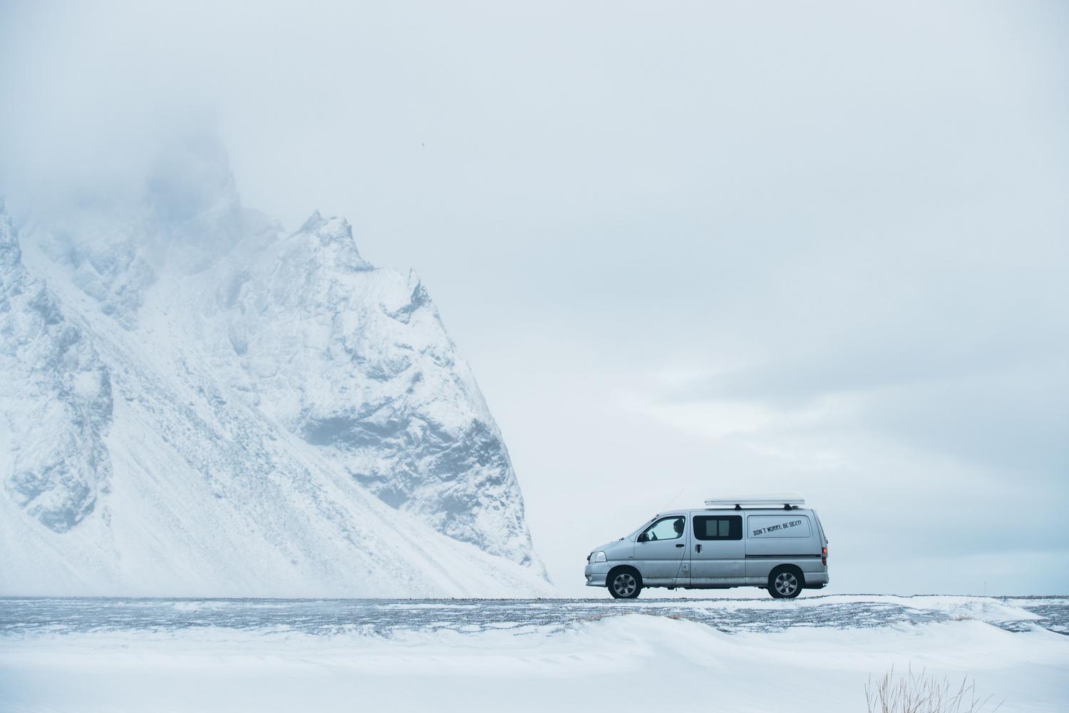 Furgoneta camper atravesando un paisaje nevado en Islandia, representando los desafíos de las baterías en climas de frío extremo. Furgoneta camper atravesando un paisaje nevado en Islandia, representando los desafíos de las baterías en climas de frío extremo.