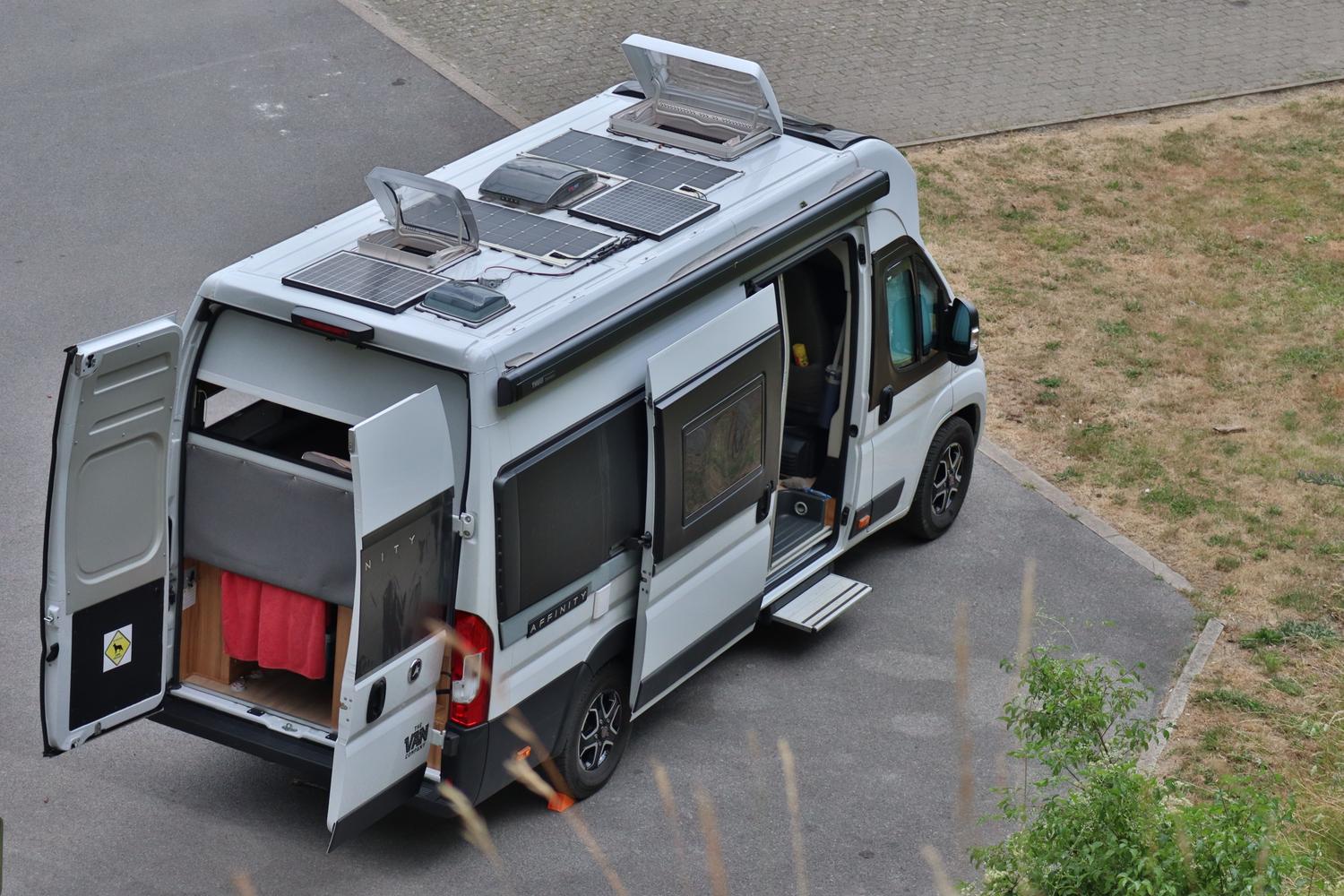 Vista aérea de una furgoneta camper con paneles solares, ejemplificando los sistemas de energía profesional para vehículos. Vista aérea de una furgoneta camper con paneles solares, ejemplificando los sistemas de energía profesional para vehículos.