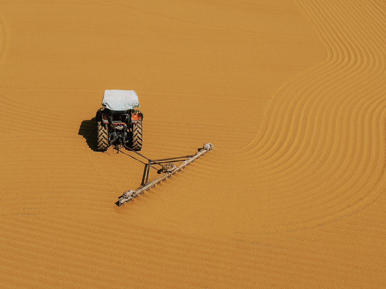 Vista aérea de un tractor realizando labores de agricultura de precisión con líneas exactas guiadas por GNSS. Vista aérea de un tractor realizando labores de agricultura de precisión con líneas exactas guiadas por GNSS.