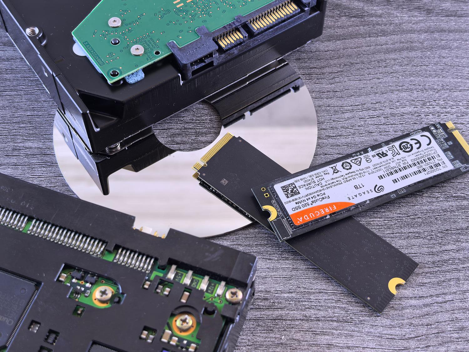 Comparativa visual de diferentes tecnologías de almacenamiento: un disco SSD, un disco duro mecánico (HDD) y un CD. Comparativa visual de diferentes tecnologías de almacenamiento: un disco SSD, un disco duro mecánico (HDD) y un CD.