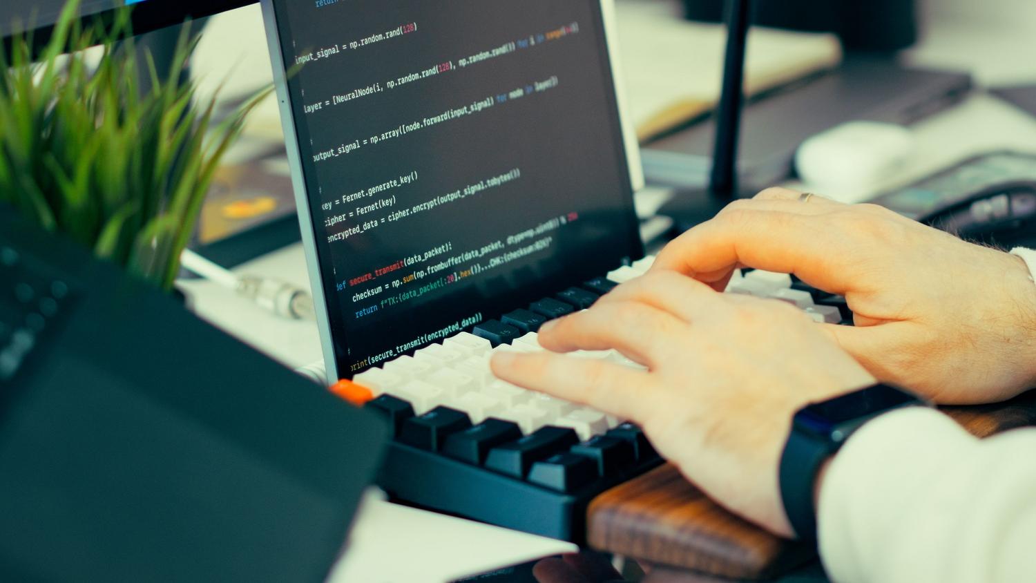 Detalle de las manos de un programador escribiendo código en un teclado, representando la fase de desarrollo y optimización. Detalle de las manos de un programador escribiendo código en un teclado, representando la fase de desarrollo y optimización.