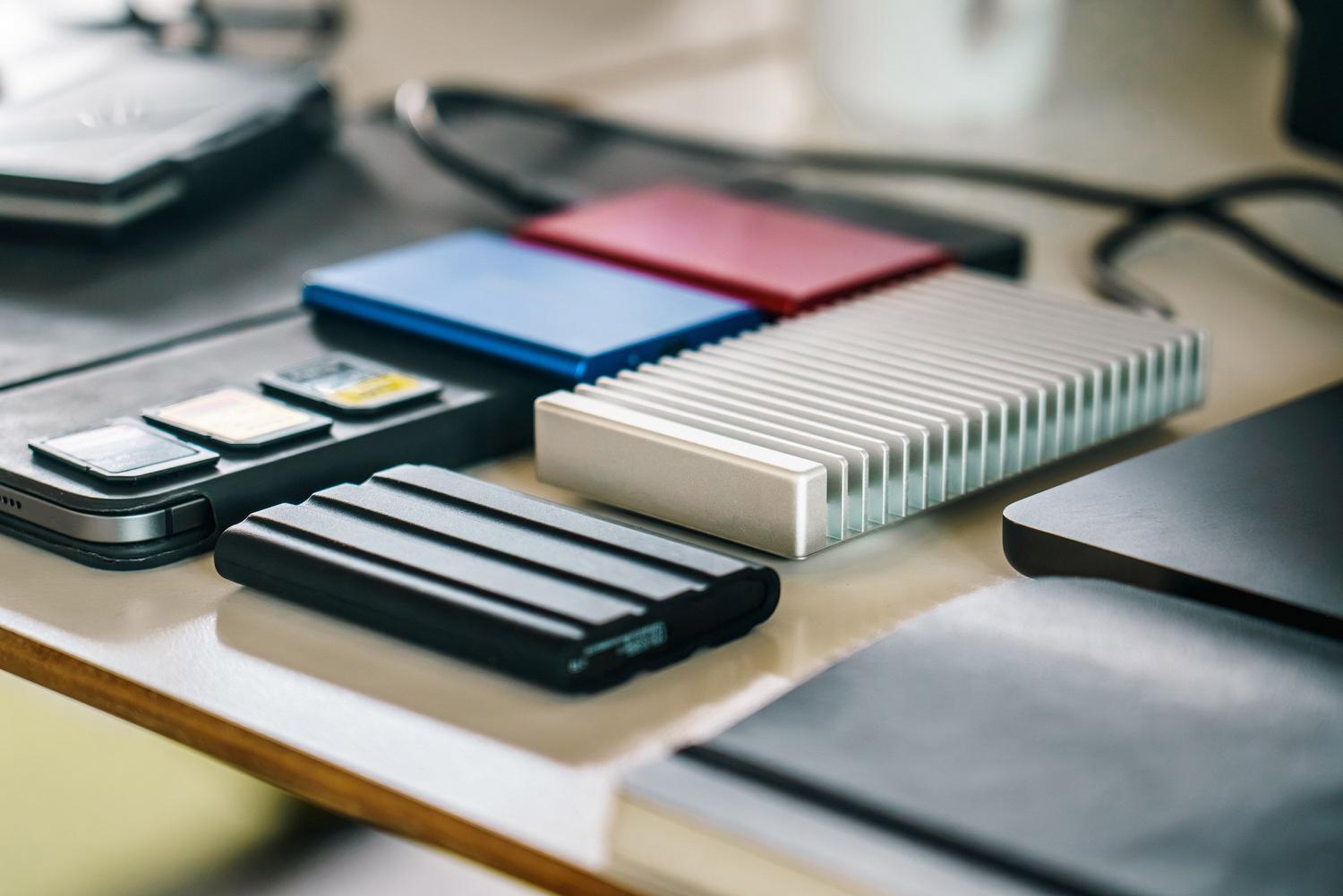 Escritorio técnico organizado con unidades SSD, tarjetas de memoria y gadgets tecnológicos modernos. Escritorio técnico organizado con unidades SSD, tarjetas de memoria y gadgets tecnológicos modernos.