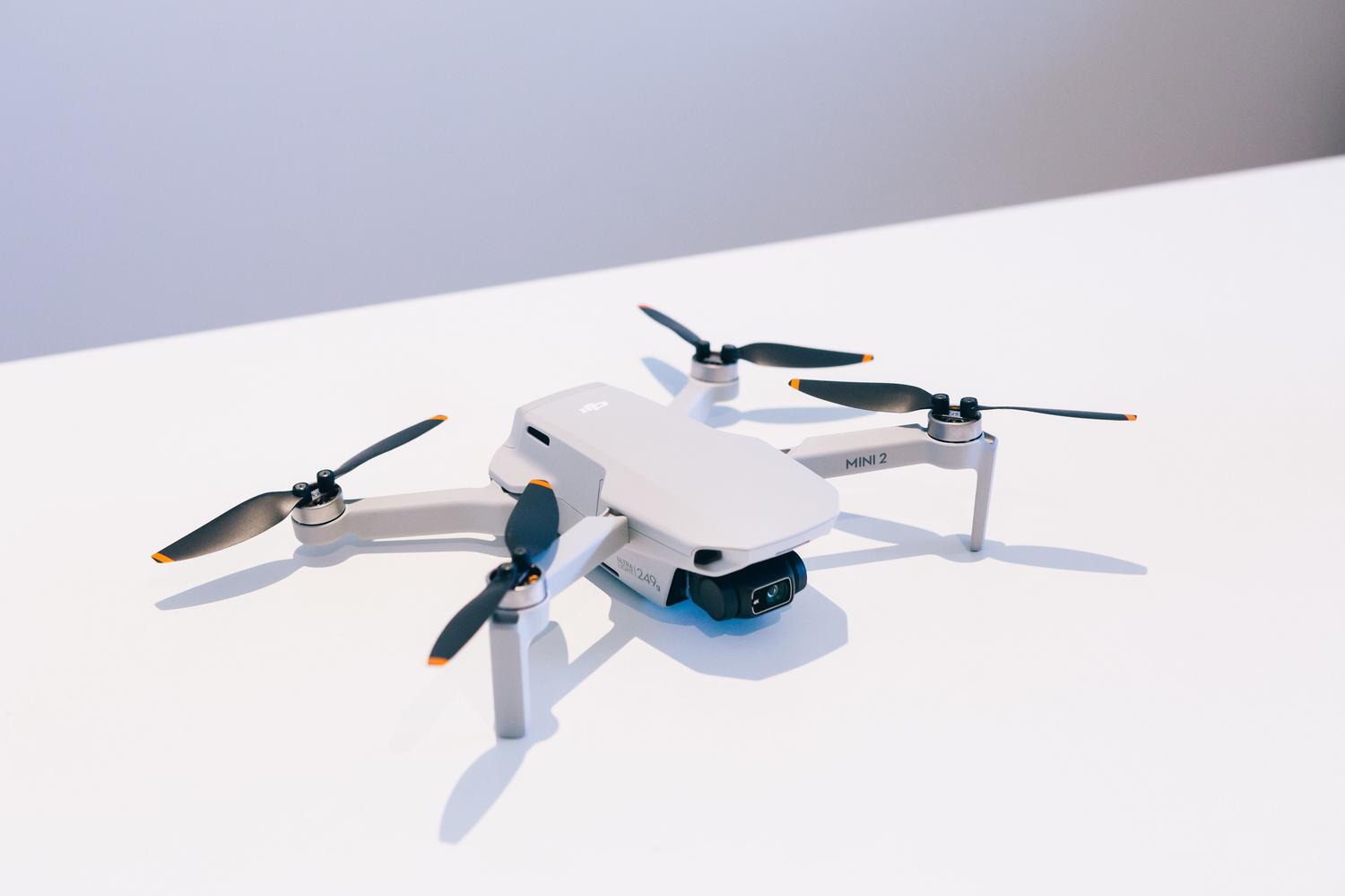 Dron compacto blanco con cámara, ejemplo de equipo para iniciación a la fotografía aérea. Dron compacto blanco con cámara, ejemplo de equipo para iniciación a la fotografía aérea.