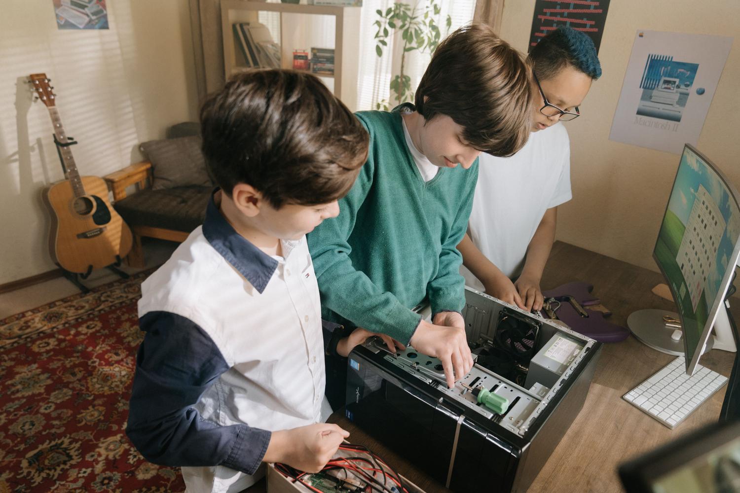 Robótica y aprendizaje tangible Niños ensamblando componentes de hardware de un ordenador, ilustrando la robótica y el aprendizaje tangible.