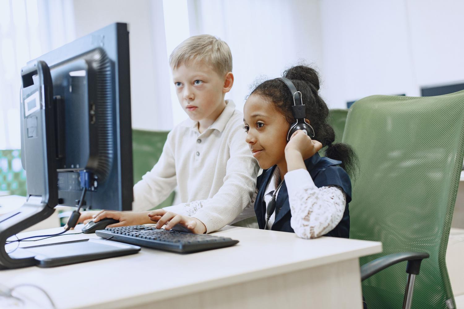 Pensamiento computacional Un niño y una niña concentrados frente a un ordenador, representando el desarrollo del pensamiento computacional.