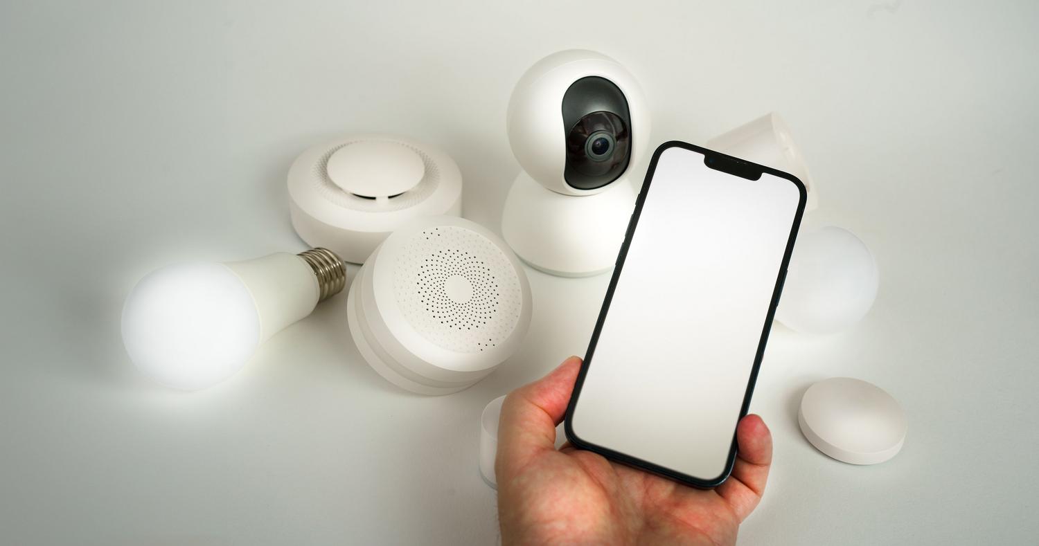 Dispositivos de hogar inteligente controlados a través de la pantalla de un smartphone, ilustrando la conectividad cloud y protocolos IoT. Dispositivos de hogar inteligente controlados a través de la pantalla de un smartphone, ilustrando la conectividad cloud y protocolos IoT.