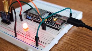 Primer plano de un microcontrolador conectado a una placa de pruebas (breadboard) con LEDs, representando la base de los proyectos IoT con ESP32 y ESP8266.