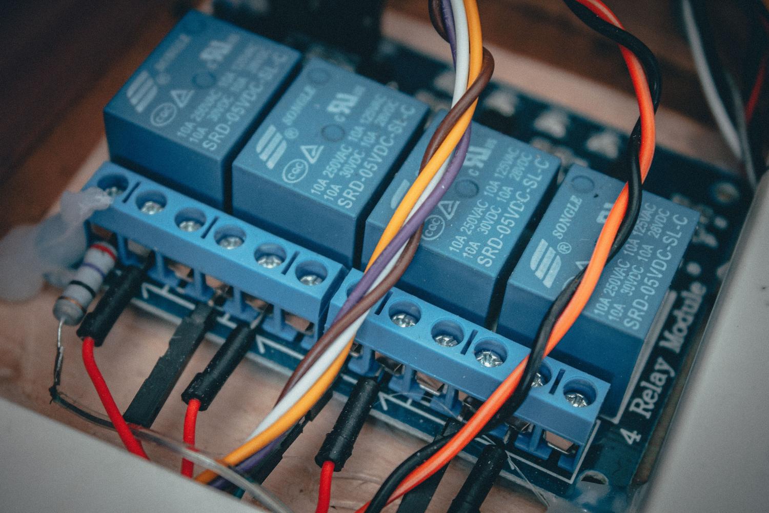 Módulos de relés electrónicos con cables de colores, representando la automatización de luces y persianas en proyectos de domótica. Módulos de relés electrónicos con cables de colores, representando la automatización de luces y persianas en proyectos de domótica.