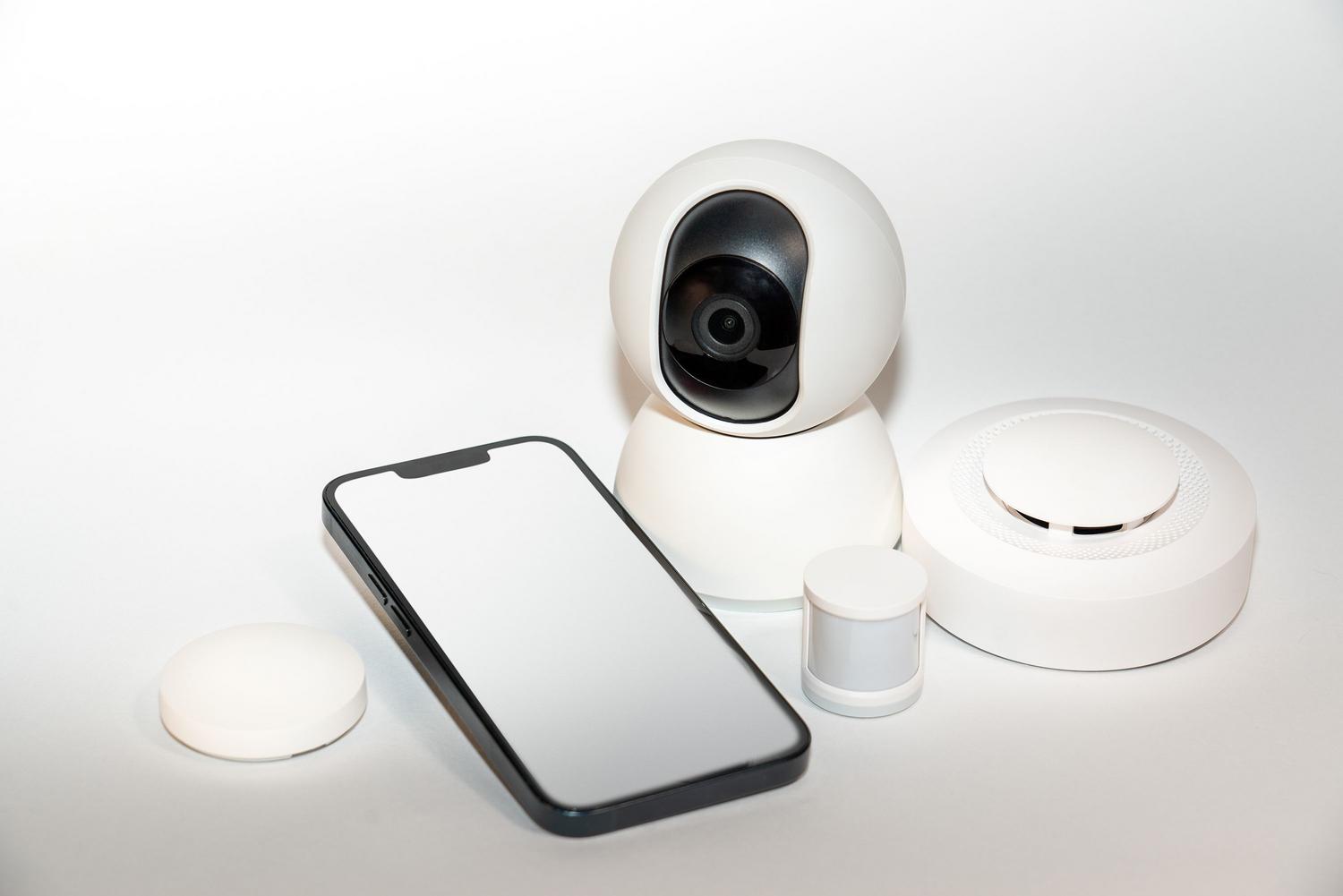 Dispositivos de seguridad inteligente y smartphone mostrando el monitoreo remoto de cámaras Dispositivos de seguridad inteligente y smartphone mostrando el monitoreo remoto de cámaras