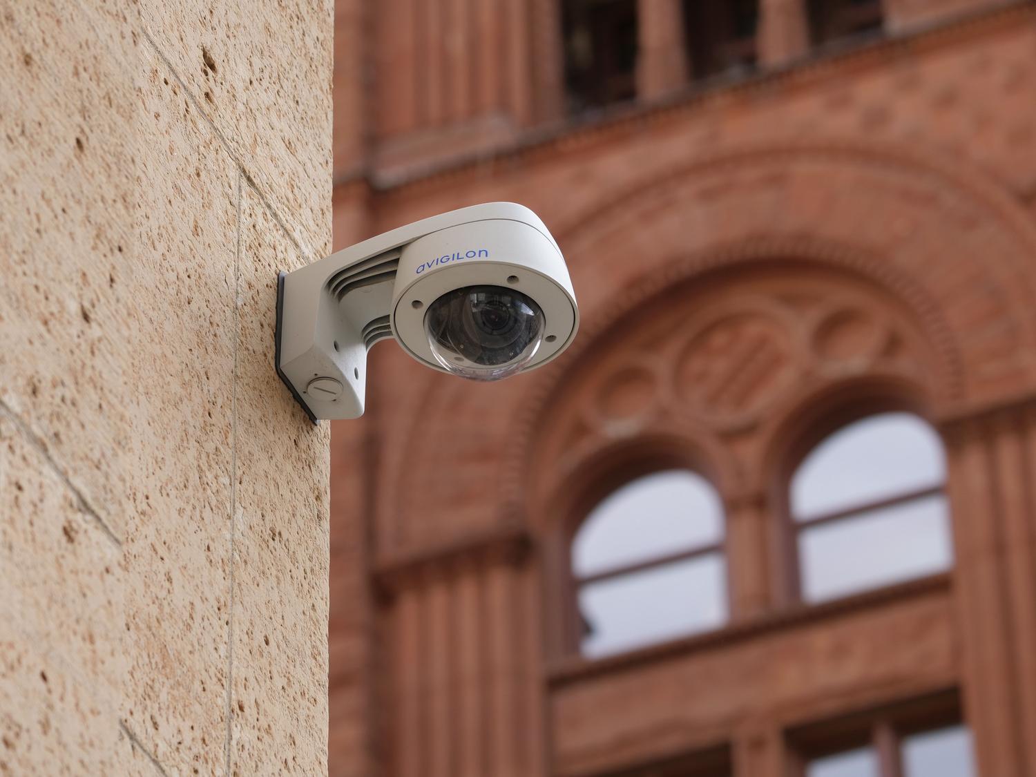 Cámara de seguridad tipo domo profesional instalada en la fachada de un edificio urbano Cámara de seguridad tipo domo profesional instalada en la fachada de un edificio urbano