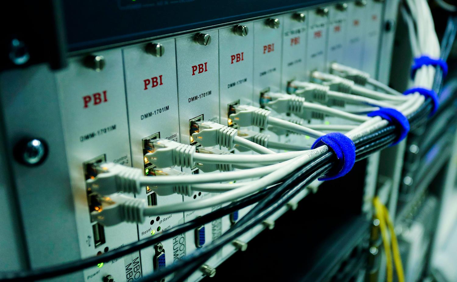 Detalle de cables Ethernet conectados a un switch de red en un centro de datos, representando la infraestructura de protocolos Detalle de cables Ethernet conectados a un switch de red en un centro de datos, representando la infraestructura de protocolos